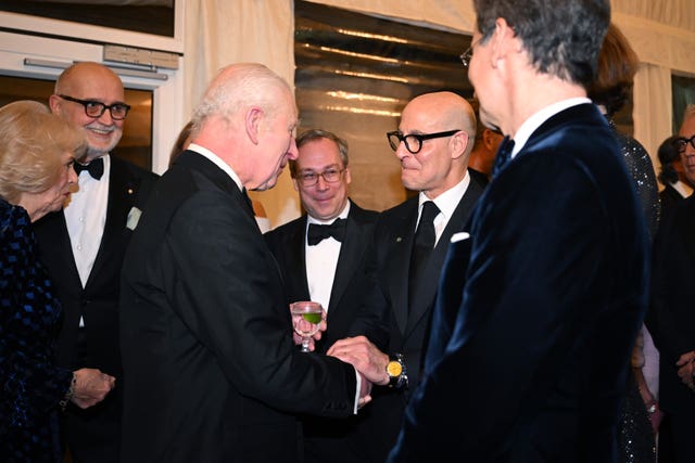 The King greets Stanley Tucci during the dinner. 