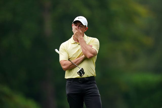 Rory McIlroy covers his mouth with his hand