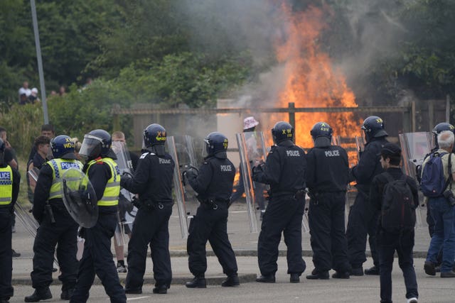 A line of police officers stand guard as trouble flares outside a hotel