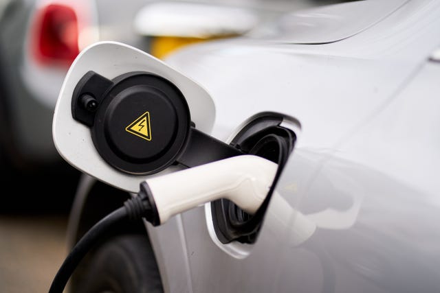 Close up of an electric vehicle charging plug plugged in to charge