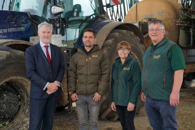 Rural Affairs Secretary Huw Irranca-Davies (left) with farm staff in front of a tractor