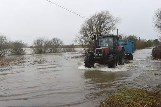 A tractor makes light work of a flooded road near Sutton, Cambridgeshire (Ben Birchall/PA)