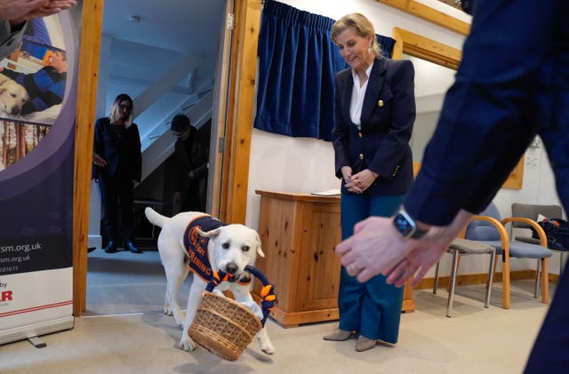 Assistance dog Buddy presents a gift basket to the Duchess of Edinburgh