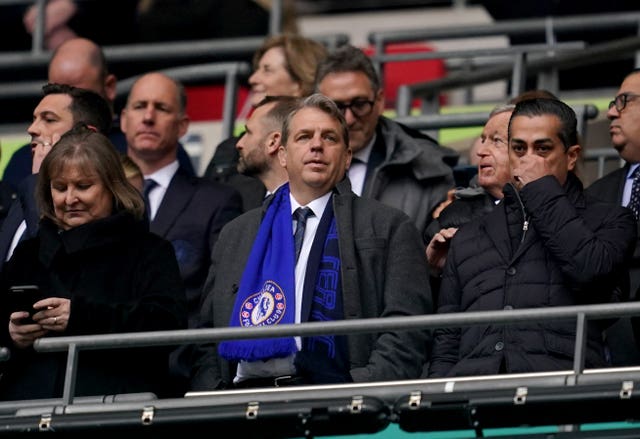 Todd Boehly stood up in a Wembley box wearing a Chelsea scarf