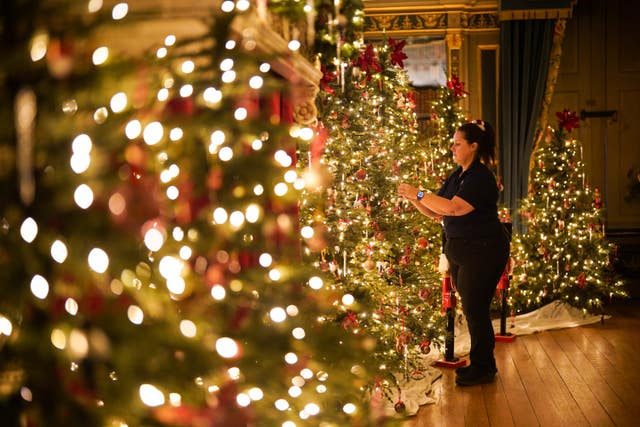 A woman decorating a Christmas tree at Warwick Castle