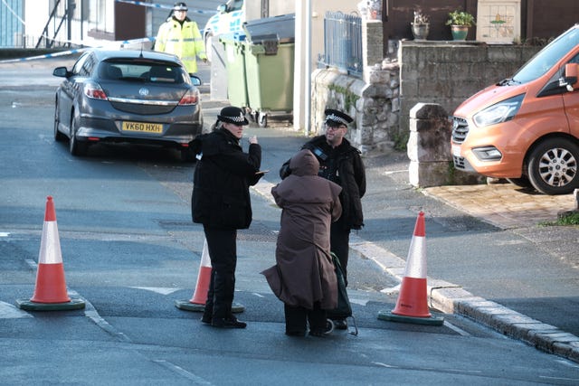 A woman speaks to police officers at a cordon near West Hoe Road