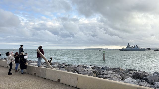 The family and loved ones of Petty Officer Daniel Easter onboard HMS Dragon as the destroyer sails from Portsmouth to the Iran war zone, watch the ship from Southsea seafront