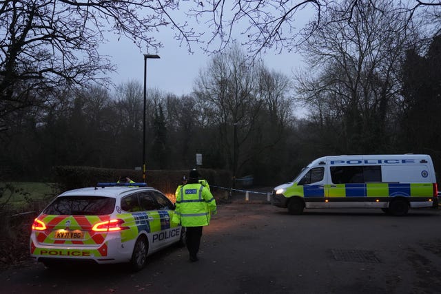 A police car and van parked close to the scene cordon