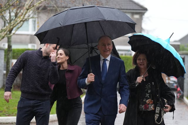 Micheal Martin arrives with an umbrella to cast his vote with his wife, Mary O'Shea