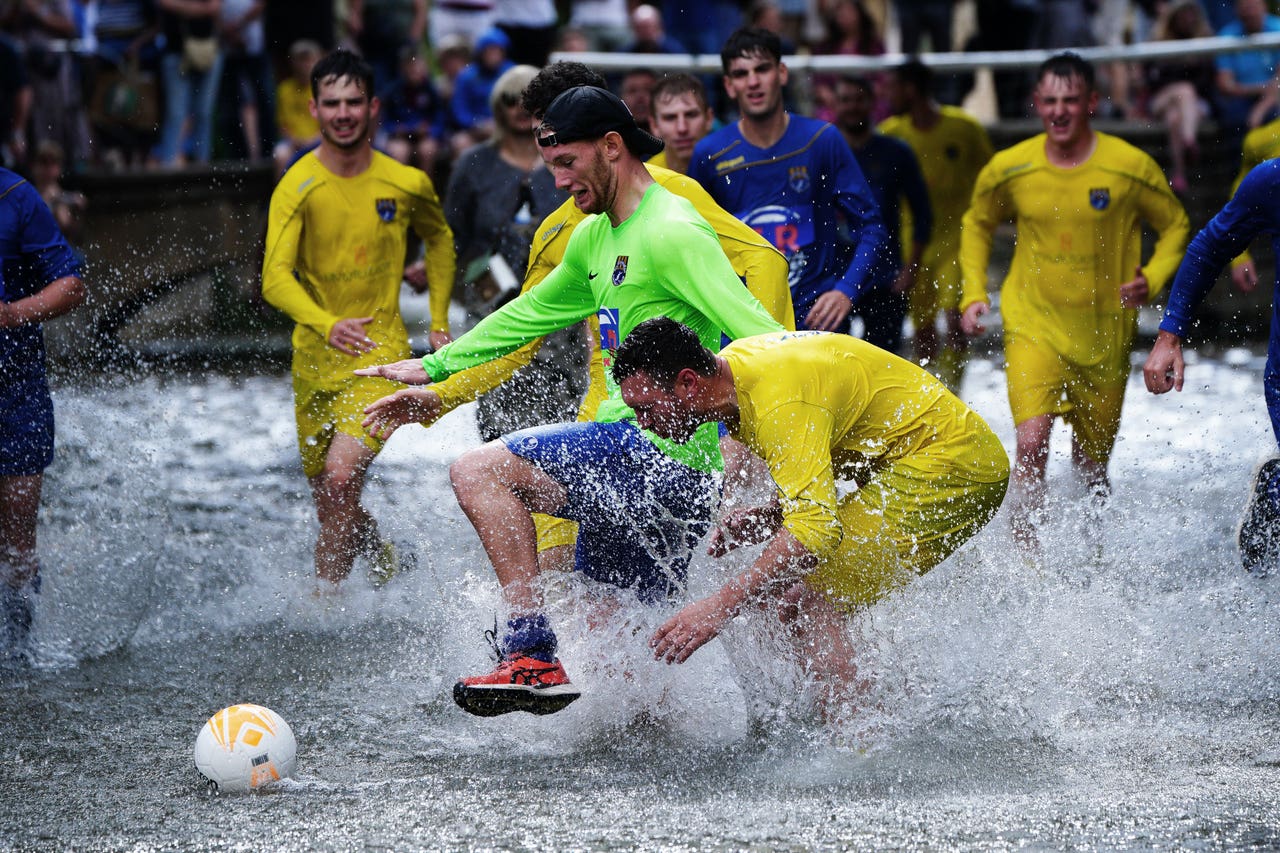 Annual river football clash goes ahead despite waterlogged pitch