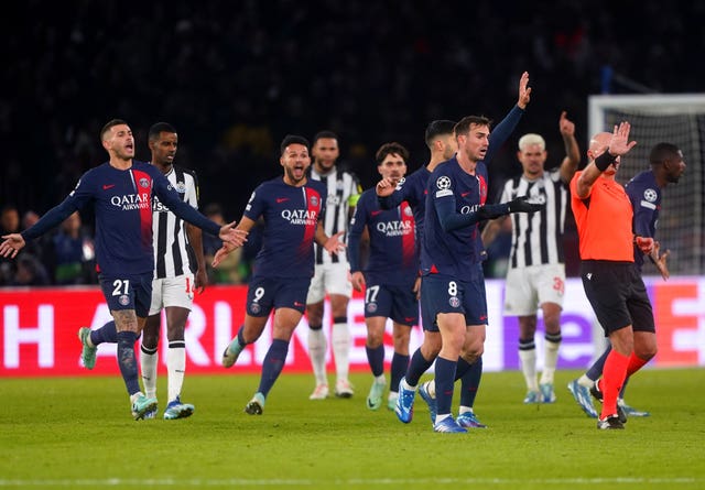 Paris Saint-Germain players surround referee Szymon Marciniak as they appeal for a penalty against Newcastle