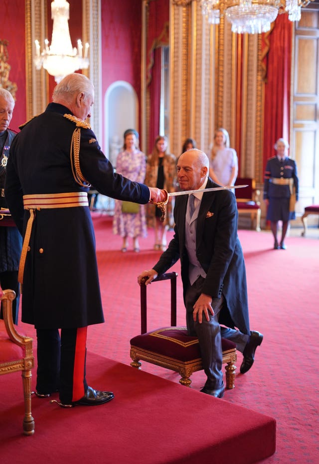 Sir Loyd Grossman being knighted by the King at Buckingham Palace