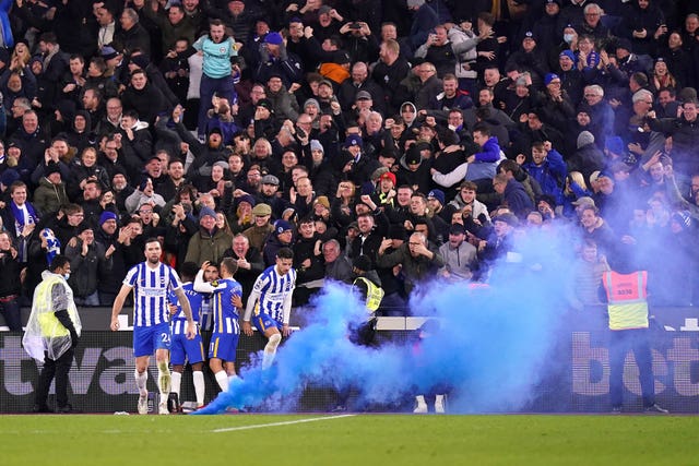 A smoke cannister is thrown onto the pitch at Brighton