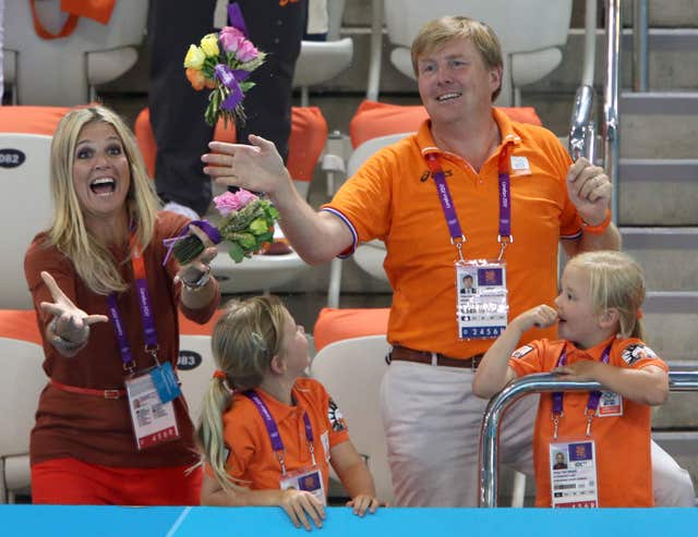 Maxima and Willem-Alexander try to catch a bouquet thrown by the Netherlands Women’s freestyle team at the London Olympics