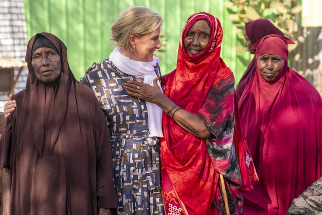 A female villager places her hand on Sophie as they meet in a Somali village in Lower Shabelle