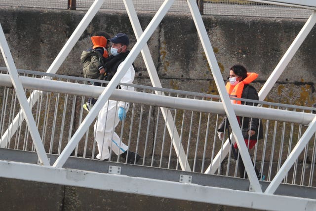 A group of people, including a child, thought to be migrants are brought into Dover, Kent
