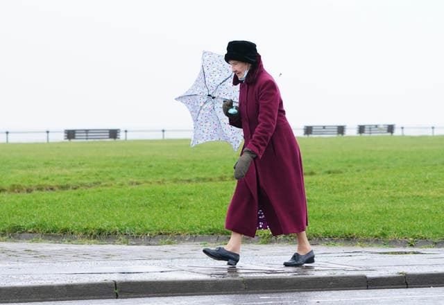 A woman walks along the sea front in Ardrossan in North Ayrshire before Storm Dudley hits the north of England/southern Scotland from Wednesday night into Thursday morning, closely followed by Storm Eunice, which will bring strong winds and the possibility of snow on Friday