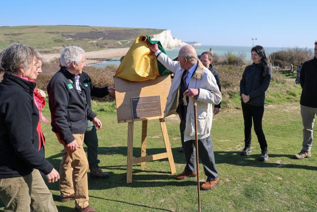 The King unveils a plaque as he inaugurates the Seven Sisters National Nature Reserve in Seaford