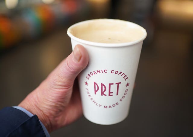 A person holds a Pret a Manger coffee in London