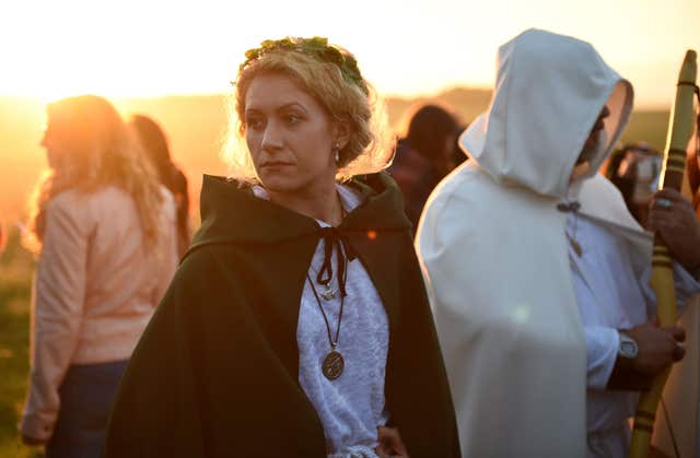 People gather at Stonehenge in Wiltshire to see in the new dawn at a summer solstice (Andrew Matthews/PA)