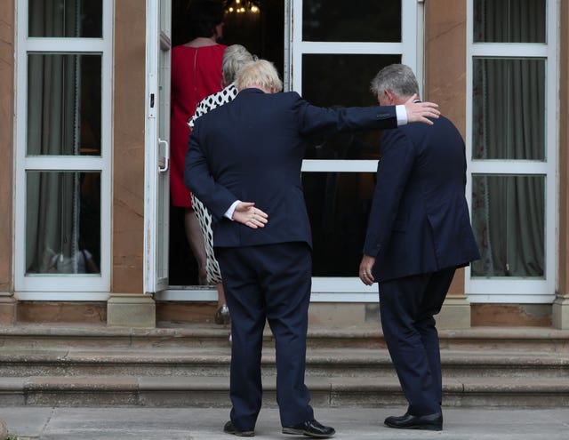 Boris Johnson gestures for Northern Ireland Secretary Brandon Lewis to enter the door ahead of him at Hillsborough Castle during the Prime Minister’s visit to Belfast