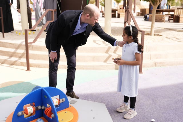 Prince of Wales talks to a small child 
