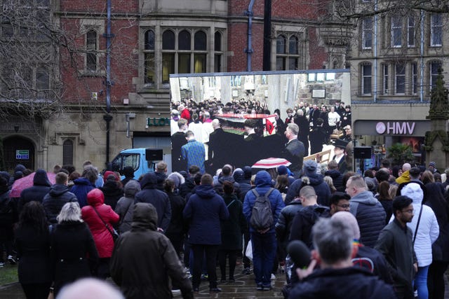 Mourners watch Harvey Willgoose's funeral service on a screen outside Sheffield Cathedral