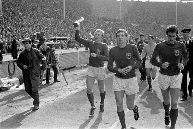 England captain Bobby Moore, left, parades the World Cup around Wembley alongside Martin Peters, second left, Geoff Hurst, right, and Gordon Banks