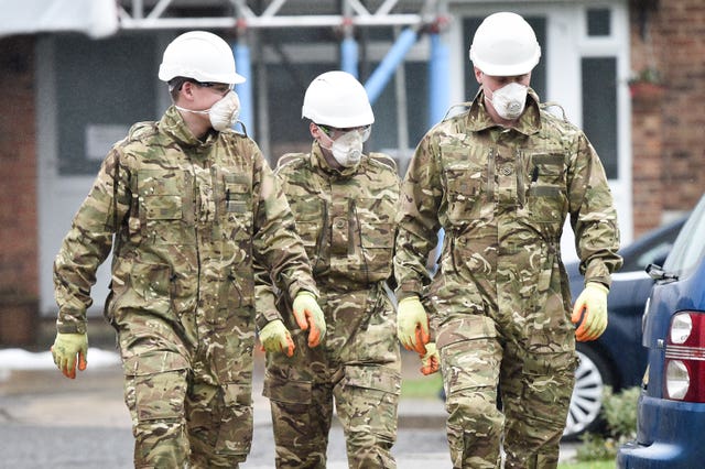 People dressed in British Army fatigues walk away from the Skripals’ house