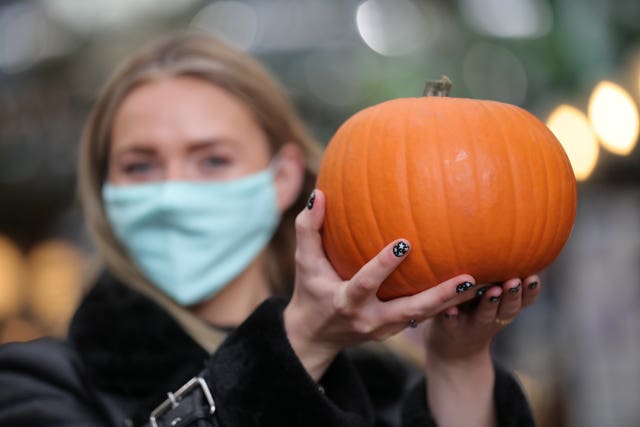 A woman holding a pumpkin at the first ever pumpkin market at Covent Garden (Aaron Chown/PA)