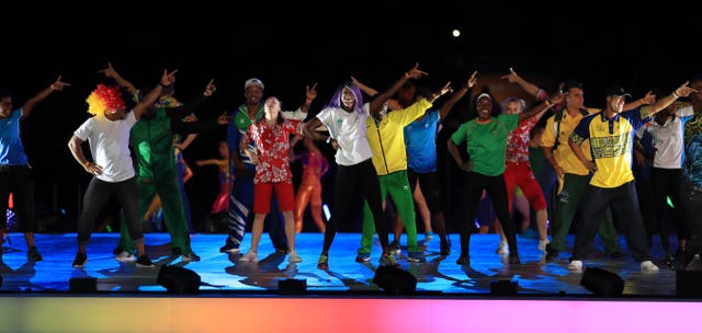 Athletes dance on stage during the closing ceremony for the 2018 Commonwealth Games at the Carrara Stadium 