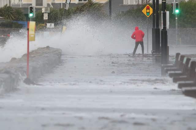 A man avoids the waves at Salthill promenade, Co Galway, during Storm Callum