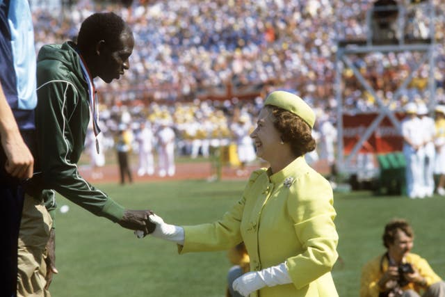 Queen Elizabeth II congratulates one of the athletes during a medal ceremony at the 1982 Commonwealth Games in Brisbane