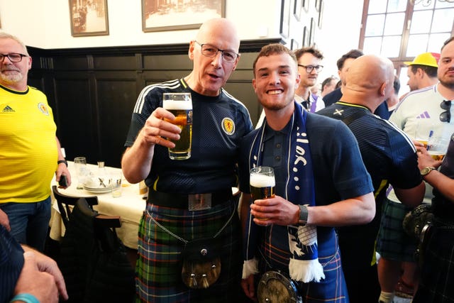 John Swinney holding a pint of lager with a fellow Scotland football supporter