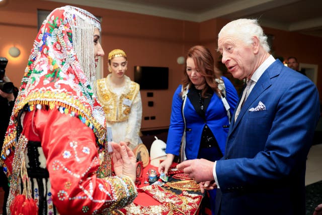 The King greets a woman in traditional dress