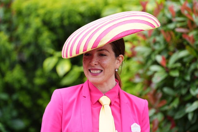 A woman wears a hat with pink and yellow sections