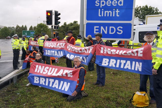 Members of Insulate Britain occupying a roundabout leading from the M25 motorway to Heathrow Airport in London in September