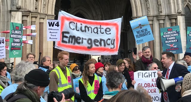 Demonstrators gather outside the Royal Courts of Justice in central London ahead of a High Court challenge to Heathrow expansion plans