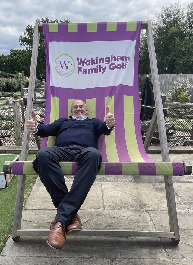 Sir Ed Davey sits in an oversized deckchair at Wokingham Family Golf in Berkshire