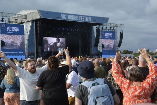 Crowds sing in front of a large stage