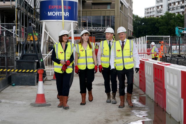 Rachel Reeves and Angela Rayner in hard hats and hi-vis tabards on a building site with two guides