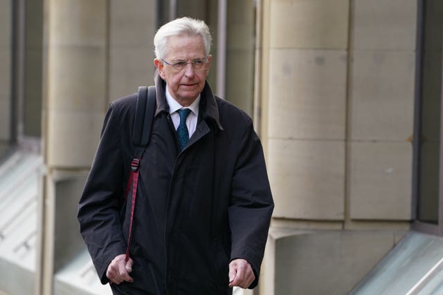 Lord Bracadale walking outside, wearing coat