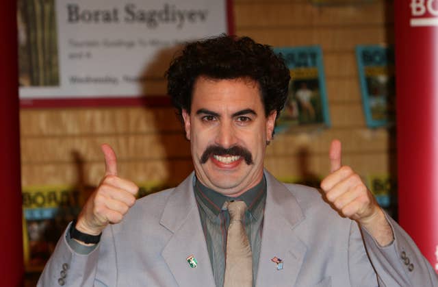 Borat signs copies of his new books Touristic Guidings to Minor Nation of U.S. and A, and Touristic Guidings to Glorious Nation of Kazakhstan