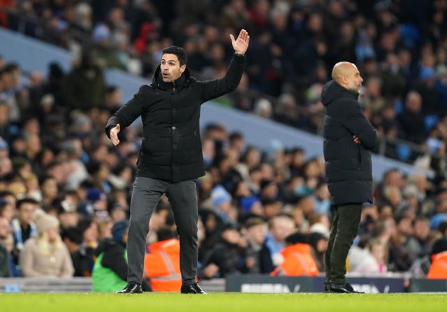 Arsenal manager Mikel Arteta, left, reacts as Manchester City manager Pep Guardiola looks on 