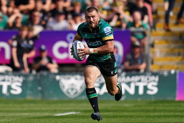 Ollie Sleightholme holds the ball as he runs down the wing for Northampton