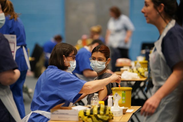 A student receives a vaccine from a medical worker