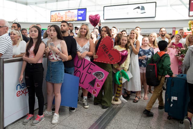 Supporters of the Love Island contestants wait to welcome them home