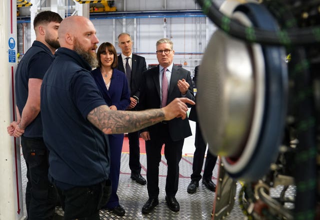 Labour leader Sir Keir Starmer (right) talking to members of staff during a visit to Rolls-Royce in Derby