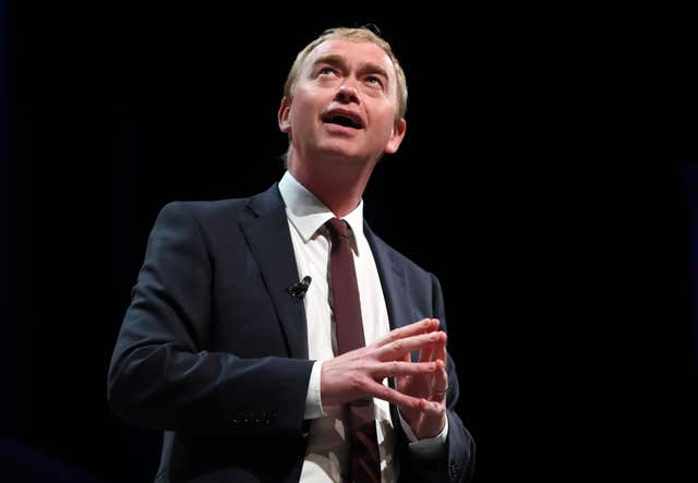 Tim Farron looking up as he stands on stage