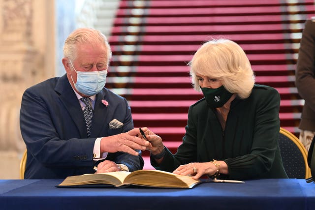 Charles and Camilla sign the visitors' book at Belfast City Hall